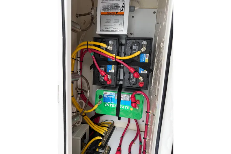 Slide: The Image of Battery compartment of 2025 Pursuit OS 325 Offshore boat with wiring and connections. - 78