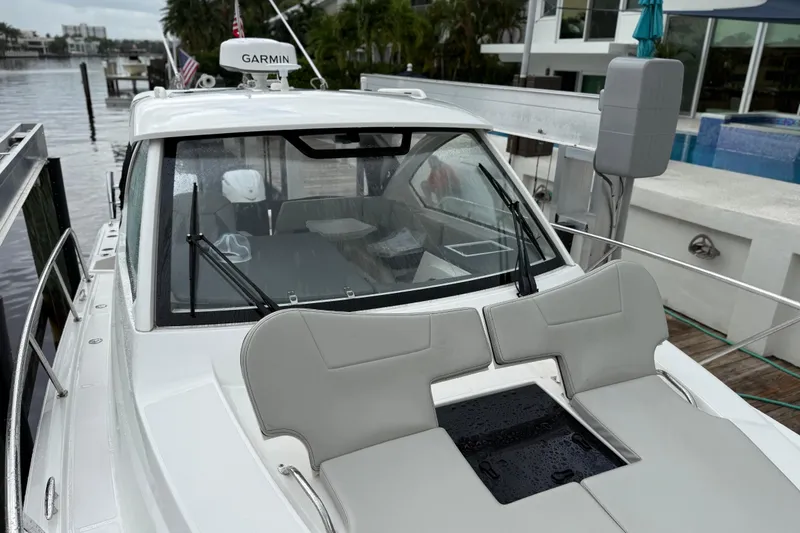 Slide: The Image of 2025 Pursuit OS 325 Offshore boat docked, featuring Garmin equipment and sleek design. - 89