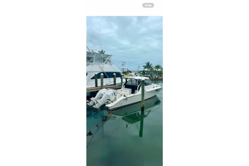 Slide: The Image of 2025 Pursuit OS 325 Offshore boat docked in a marina with palm trees. - 94