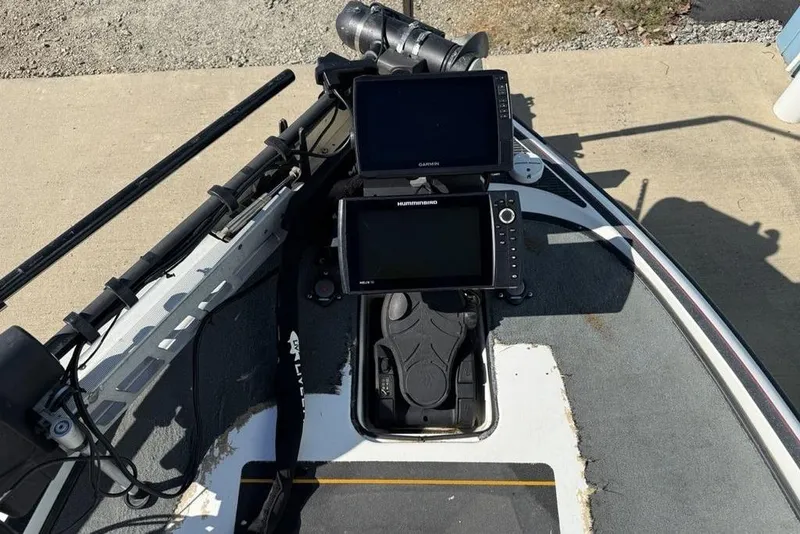 Slide: The Image of Open storage compartment in a 2005 Triton TR-21 boat, featuring cup holders and carpeted interior. - 11