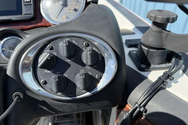 Slide: The Image of 2005 Triton TR-21 boat interior with red and gray seats, steering wheel, and dashboard stickers. - 14