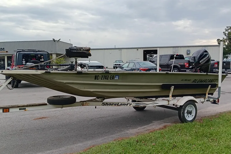 Slide: The Image of 2006 Alumacraft Crappie Jon boat on trailer, parked outdoors near vehicles. - 2