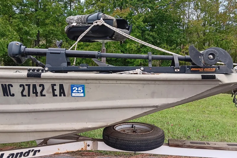 Slide: The Image of 2006 Alumacraft Crappie Jon boat with trolling motor on trailer, parked on grass. - 7