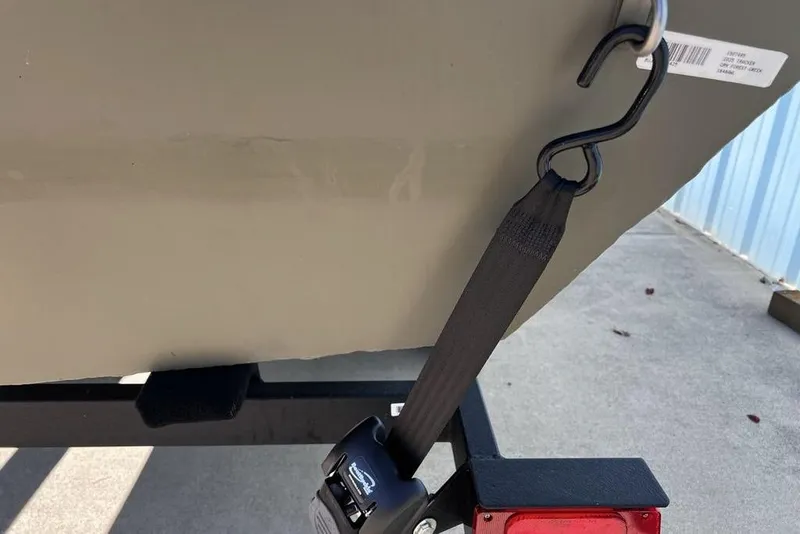 Slide: The Image of 2025 Tracker Grizzly 1648 Utility boat secured with a strap on a trailer. - 4