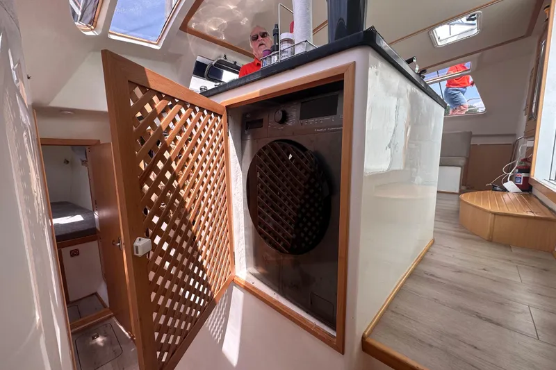 Slide: The Image of Interior of 2021 Celtic Yachts 40, featuring a built-in washing machine and wooden lattice door. - 15