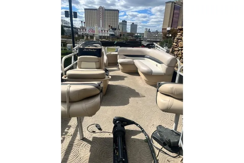 Slide: The Image of 2013 Sun Tracker Bass Buggy 18 DLX pontoon boat with beige seating in urban setting. - 36