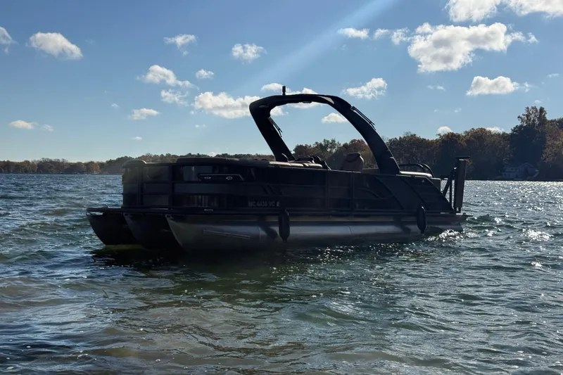 The Image of 2025 Bentley Pontoons Elite 253 Admiral on a sunny lake, surrounded by trees. - 0