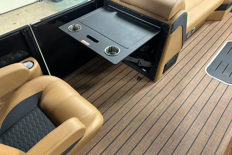Slide: The Image of 2025 Bentley Pontoons Elite 253 Admiral interior with tan seating and foldable table. - 22