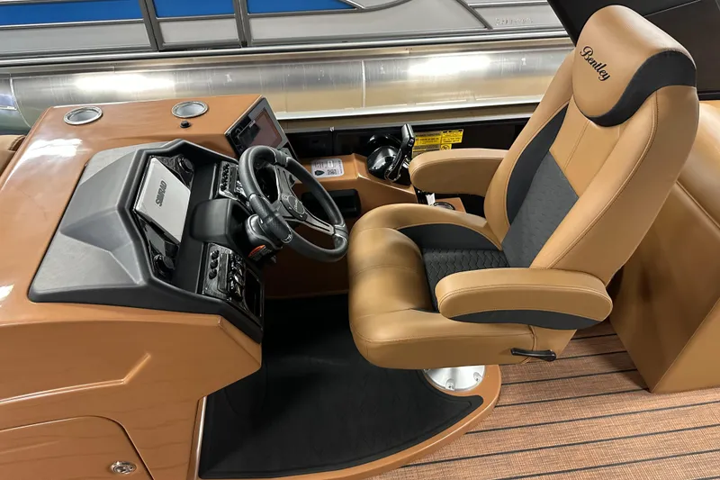 Slide: The Image of 2025 Bentley Pontoons Elite 253 Admiral helm with luxurious captain's chair and modern dashboard. - 25
