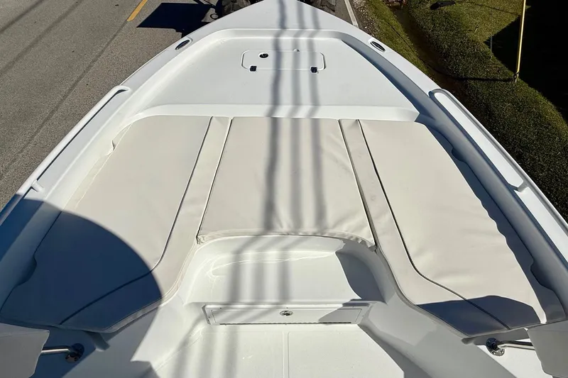 Slide: The Image of 2026 Sea Hunt BX 25 FS boat deck with cushioned seating, parked on a road. - 15
