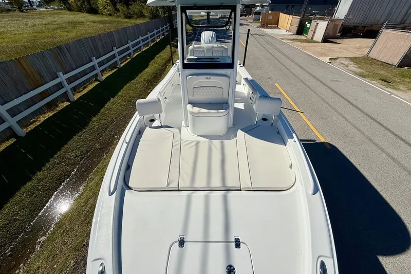 Slide: The Image of 2026 Sea Hunt BX 25 FS boat, white interior, parked on a road near a fence. - 18