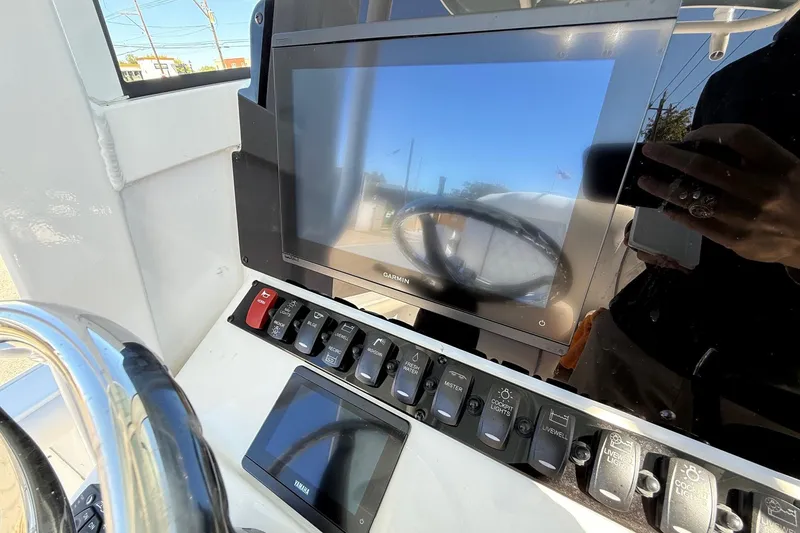 Slide: The Image of Control panel of 2026 Sea Hunt BX 25 FS boat with Garmin display and switches. - 19
