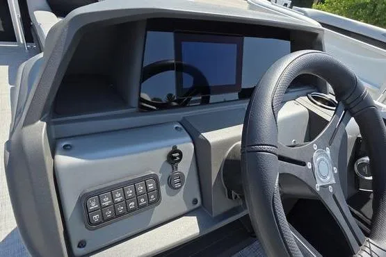 Slide: The Image of 2026 Sun Tracker PB 20 DLX dashboard with steering wheel and control panel. - 19