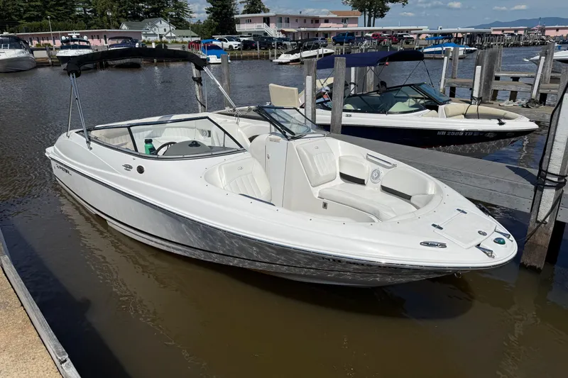 The Image of 2007 Regal 2400 Bowrider boat on trailer, parked outdoors with trees in background. - 0