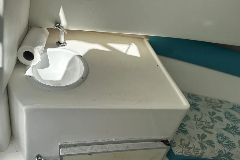 Slide: The Image of 2000 Cobia 240 Walkaround boat interior with sink and paper towel holder. - 11