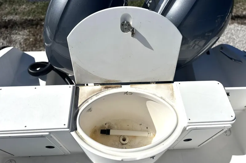 Slide: The Image of Open storage compartment on a 2000 Cobia 240 Walkaround boat, showing interior details. - 13