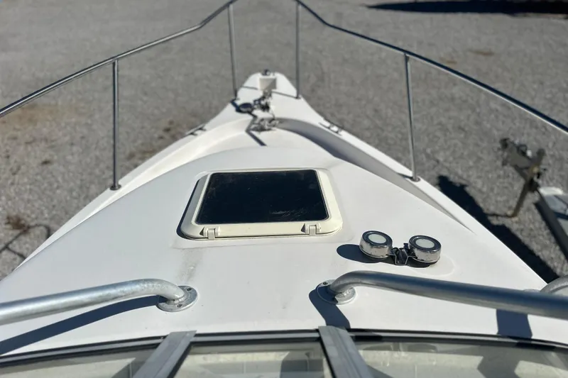 Slide: The Image of Bow view of 2000 Cobia 240 Walkaround boat on gravel surface. - 14
