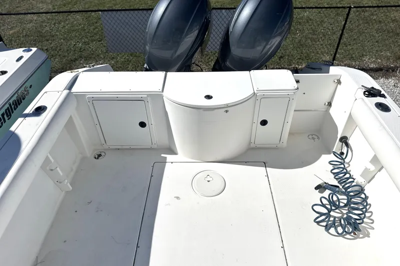 Slide: The Image of 2000 Cobia 240 Walkaround boat deck with storage compartments and coiled hose. - 16