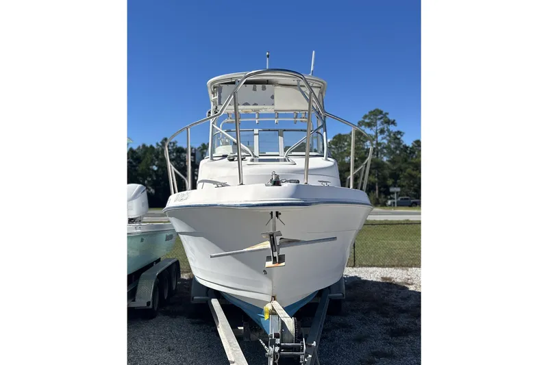 Slide: The Image of 2000 Cobia 240 Walkaround boat on trailer under clear blue sky. - 2