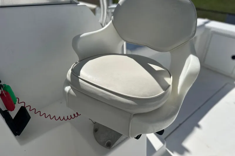 Slide: The Image of White captain's chair on 2000 Cobia 240 Walkaround boat, featuring sleek design and comfort. - 6