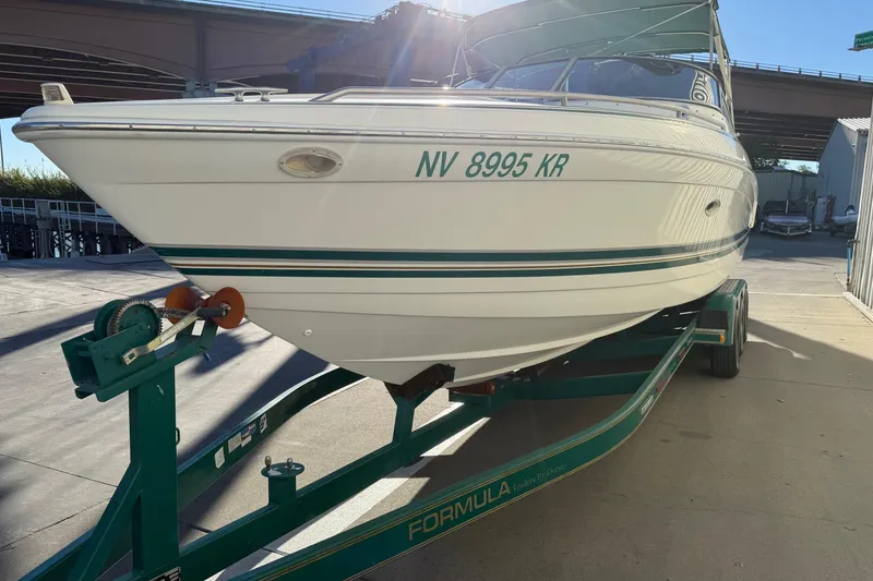 Slide: The Image of 2000 Formula 280 Sun Sport boat on trailer, parked under a bridge in sunlight. - 3