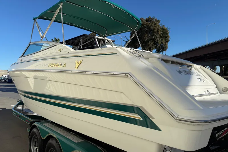 Slide: The Image of 2000 Formula 280 Sun Sport boat with green accents on a trailer, sunny day. - 5