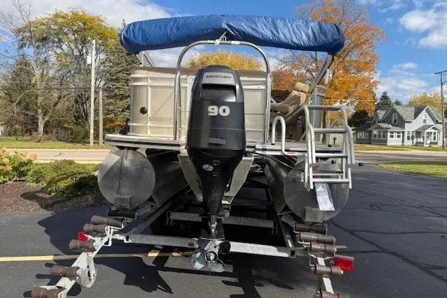 Slide: The Image of 2014 Harris FloteBote Sunliner 200 pontoon boat with Mercury 90 engine, parked on trailer. - 2