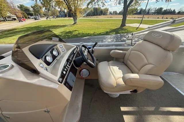 Slide: The Image of 2014 Harris FloteBote Sunliner 200 boat interior with beige captain's chair and control panel. - 6