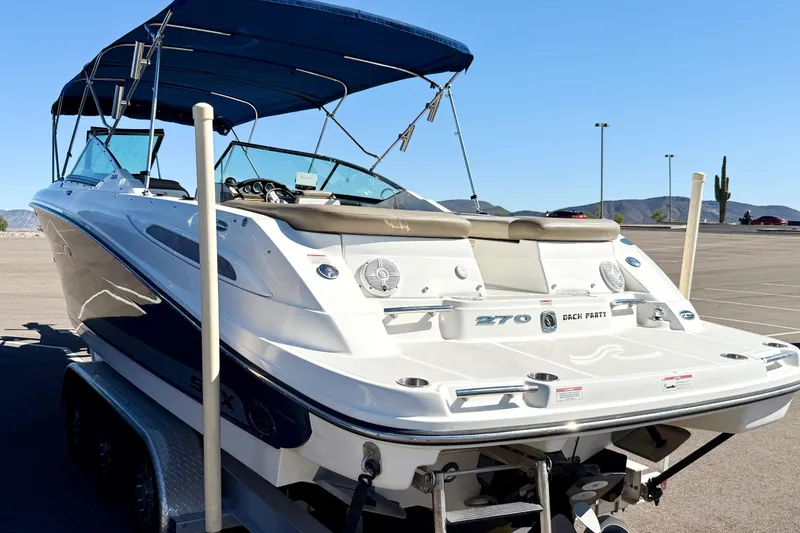 Slide: The Image of 2011 Sea Ray 270 SLX boat on trailer with blue canopy in sunny setting. - 5