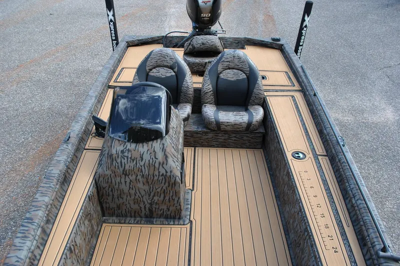 Slide: The Image of 2024 Express 180XP boat interior with camo seats and wood-patterned flooring. - 17