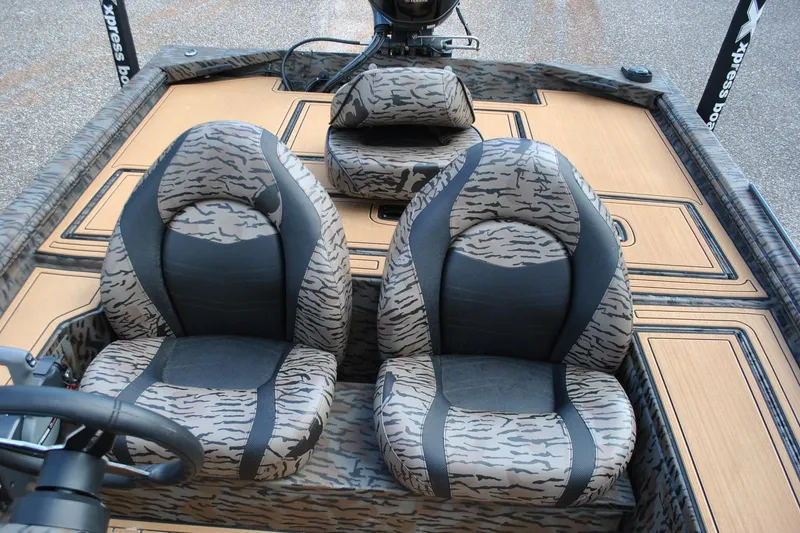 Slide: The Image of 2024 Express 180XP boat interior with camo-patterned seats and steering wheel. - 19
