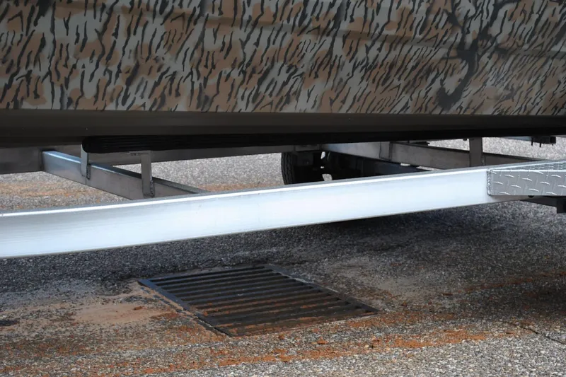 Slide: The Image of 2024 Express 180XP boat trailer with camouflage design on pavement. - 26