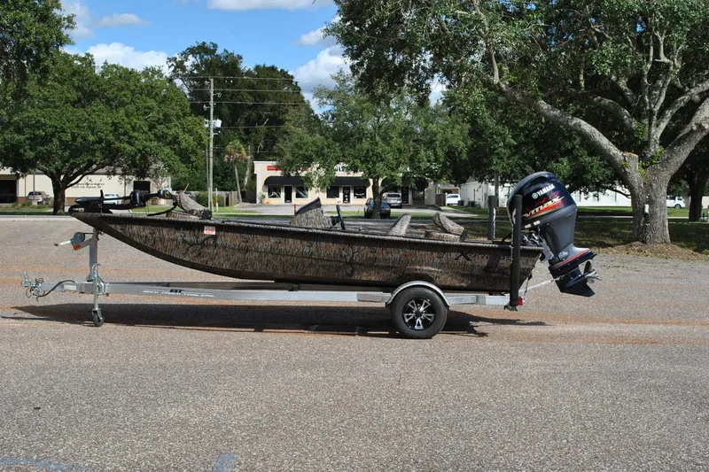 Slide: The Image of 2024 Express 180XP boat on trailer with Yamaha outboard motor, parked outdoors. - 27