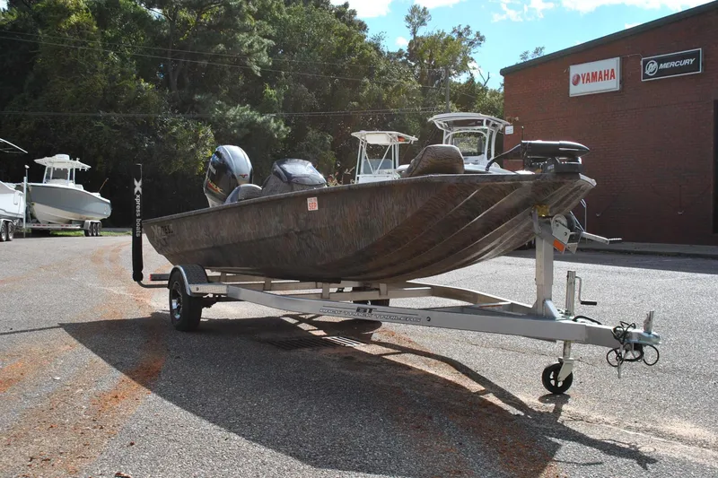 Slide: The Image of 2024 Express 180XP boat on trailer, parked outdoors near Yamaha and Mercury signs. - 30