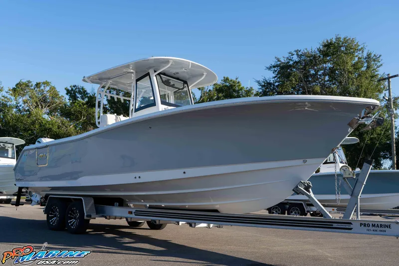 Slide: The Image of 2026 Sea Hunt Ultra 285 SE boat on trailer, displayed outdoors under clear blue sky. - 14