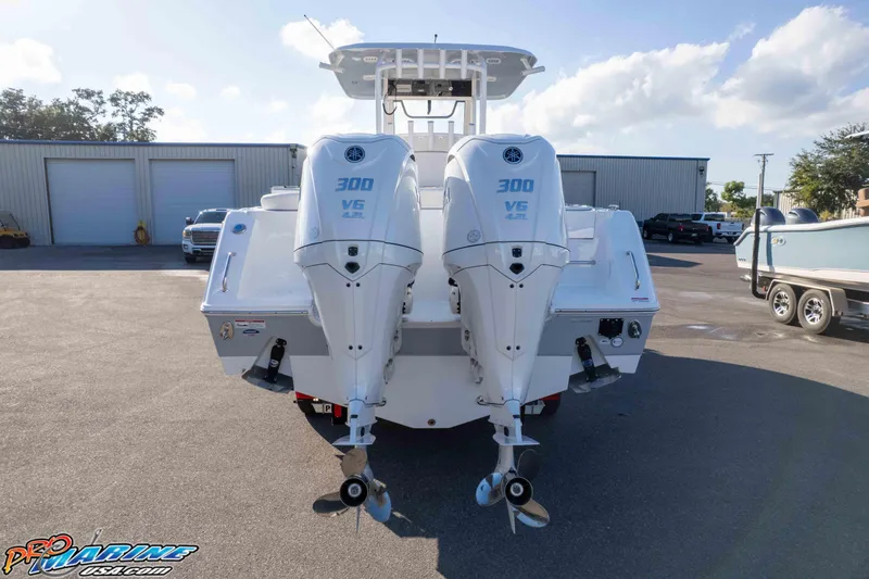 Slide: The Image of 2026 Sea Hunt Ultra 285 SE with twin 300 V6 engines, parked outdoors. - 25