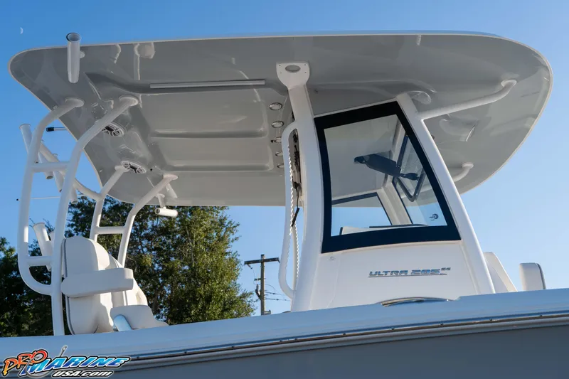 Slide: The Image of 2026 Sea Hunt Ultra 285 SE boat with T-top and console, under clear blue sky. - 38