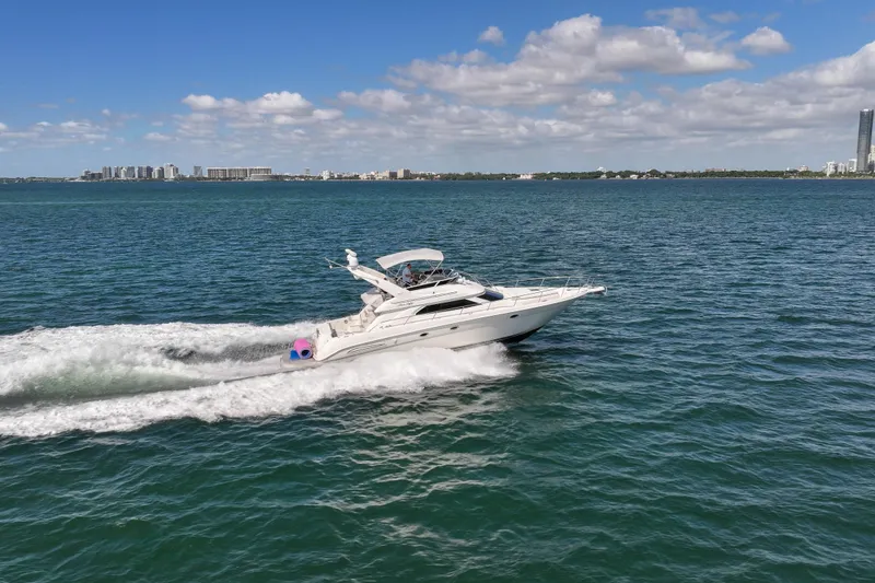 Slide: The Image of 2000 Sea Ray 450 Express Bridge cruising on open water under a clear blue sky. - 12