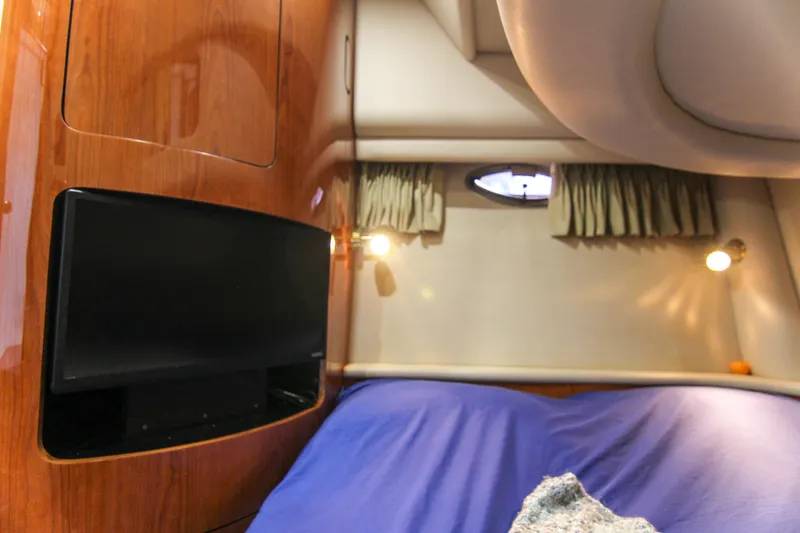 Slide: The Image of Interior cabin of 2000 Sea Ray 450 Express Bridge with TV and cozy bedding. - 26