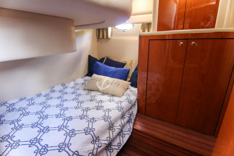 Slide: The Image of Cozy cabin interior of 2000 Sea Ray 450 Express Bridge with nautical bedding. - 29