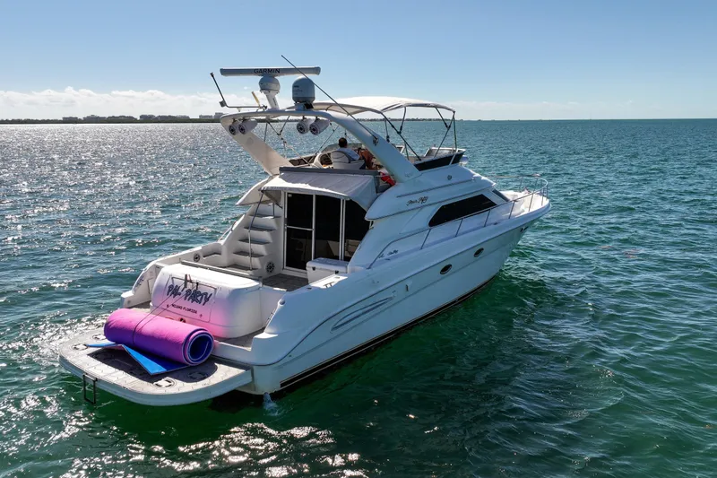 Slide: The Image of 2000 Sea Ray 450 Express Bridge yacht on open water, sunny day, rear view. - 7