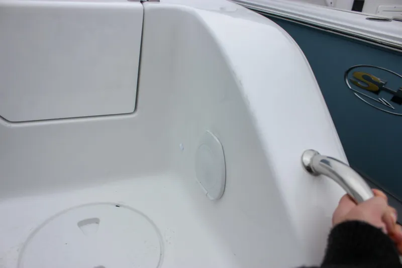 Slide: The Image of 2026 Sea Hunt Ultra 265 SE boat interior with brown cushioned seating and storage compartment. - 12