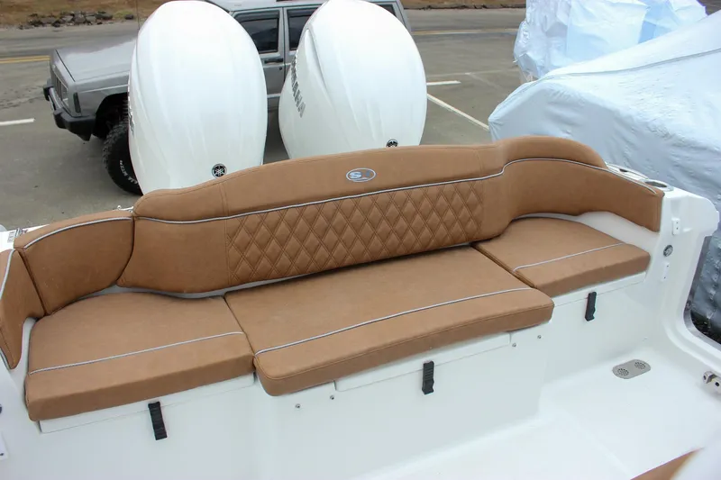 Slide: The Image of 2026 Sea Hunt Ultra 265 SE boat interior with brown seating and blue canopy. - 14