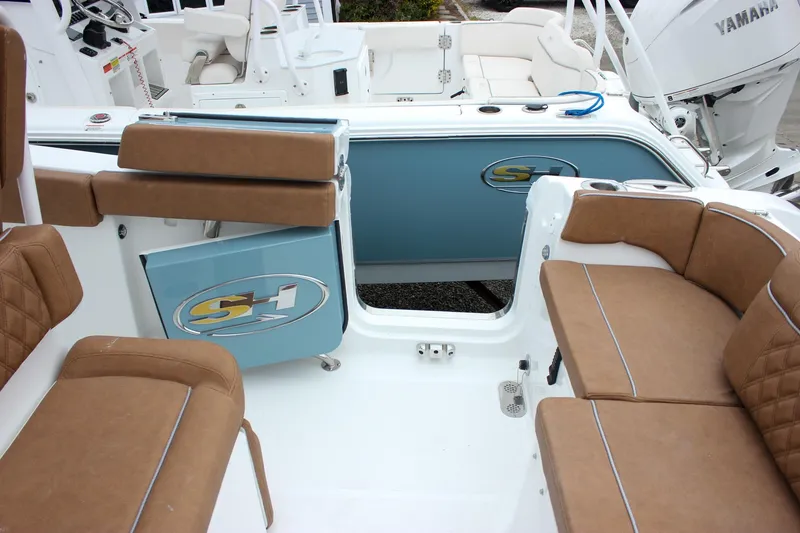 Slide: The Image of 2026 Sea Hunt Ultra 265 SE boat interior with tan seating and storage compartment. - 16