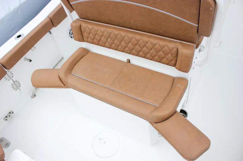 Slide: The Image of 2026 Sea Hunt Ultra 265 SE boat interior with brown cushioned seating. - 21