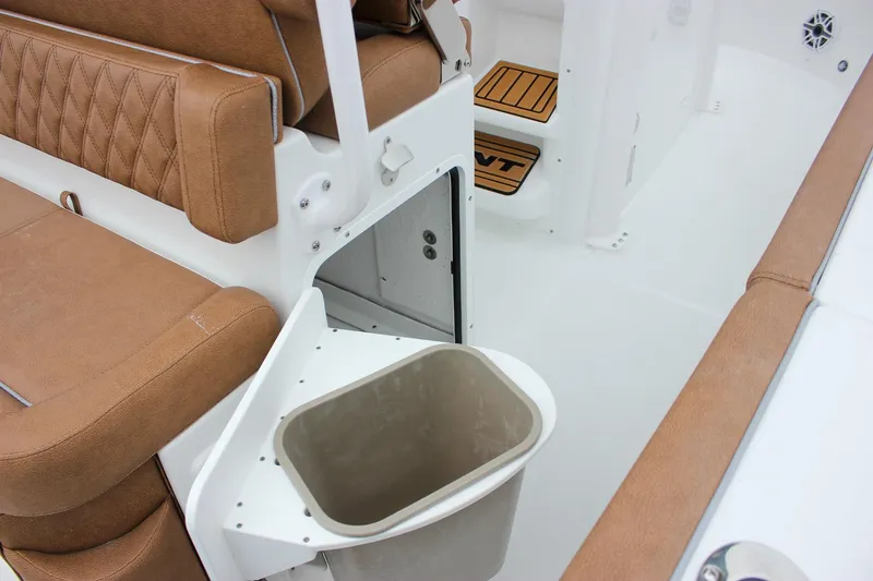 Slide: The Image of 2026 Sea Hunt Ultra 265 SE boat interior with brown cushioned seating and white storage compartment. - 23