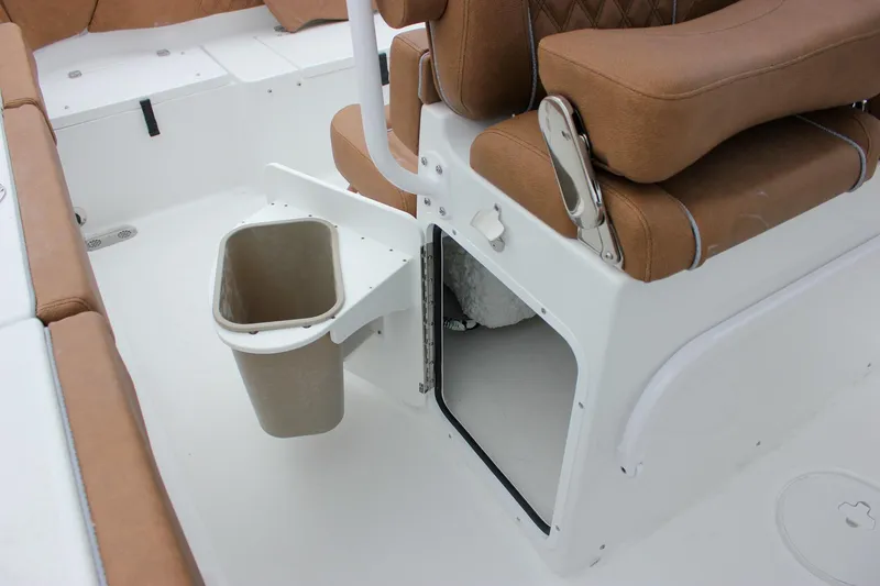 Slide: The Image of 2026 Sea Hunt Ultra 265 SE boat interior with tan seating and built-in storage. - 24