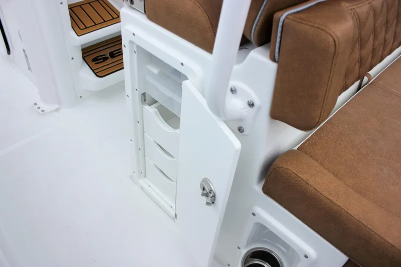 Slide: The Image of 2026 Sea Hunt Ultra 265 SE boat interior with brown cushioned seating and white deck. - 29