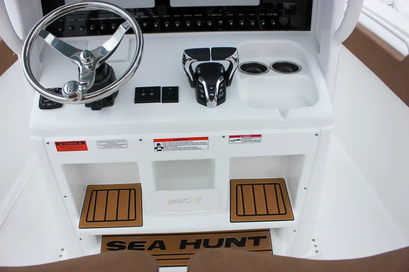 Slide: The Image of 2026 Sea Hunt Ultra 265 SE boat interior with brown seating and storage compartment. - 30