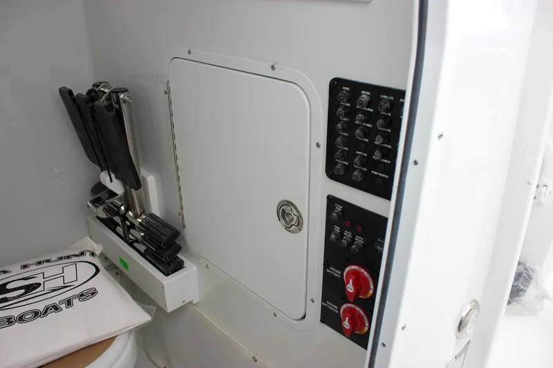 Slide: The Image of 2026 Sea Hunt Ultra 265 SE boat interior storage compartment with open door. - 44